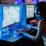 Woman enjoying a vibrant gaming session at a computer setup with a mechanical keyboard.